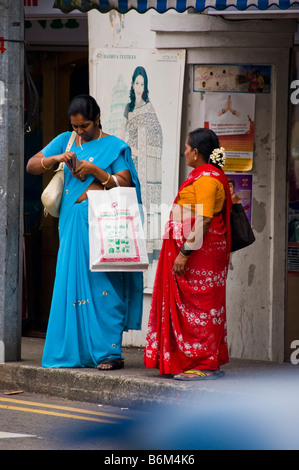 La femme debout sur rue dans Little India à Singapour en attente pour le bus Banque D'Images