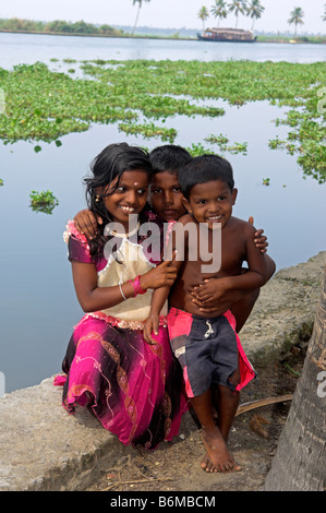 Trois jeunes enfants sur les rives du canal en Backwaters du Kerala Inde Banque D'Images