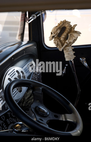 Un pommeau du levier de vitesses avec un crâne/construction ajourée sur elle, dans un hot rod à une exposition de voiture. Banque D'Images