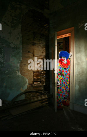 Sinistre Clown rôdant à travers un bâtiment condamné Banque D'Images