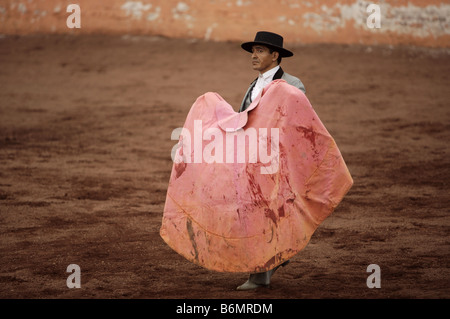 Un torero est titulaire d'un cap éclaboussés de sang qu'il attend d'être un taureau de facturer au cours d'une corrida dans la ville de Mexico Banque D'Images