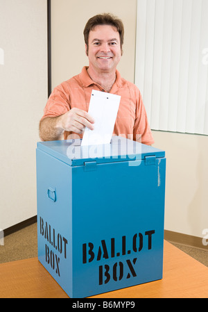 Middle aged man déposer son bulletin dans l'élection Banque D'Images