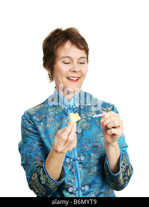 Une femme lisant le message à partir d'un biscuit de fortune isolated on white Banque D'Images