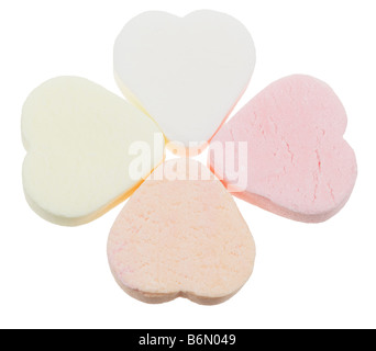 Bonbons bonbons en forme de cœur dans une forme de trèfle chanceux en amour isolé sur fond blanc Banque D'Images