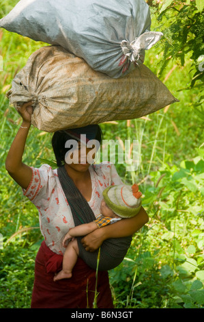 Femme karens birmans en Thaïlande de passage avec son bébé et effets personnels Banque D'Images