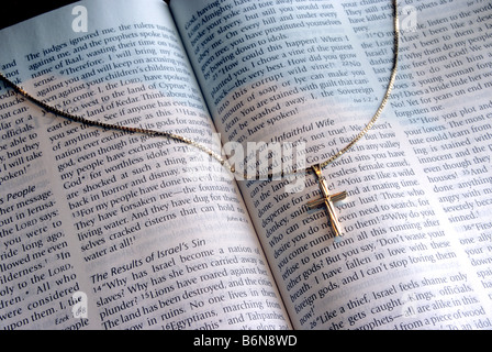 Collier croix en or portant sur une bible ouverte still life Banque D'Images