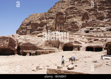 Leader arabe âne en face de bâtiments sculptés sur le côté de la falaise, à Petra, Wadi Musa, Jordan Banque D'Images