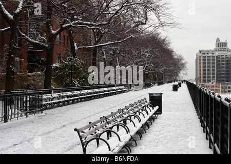 Bancs couverts de neige sont vus sur une promenade à Brooklyn, New York après une tempête. Banque D'Images