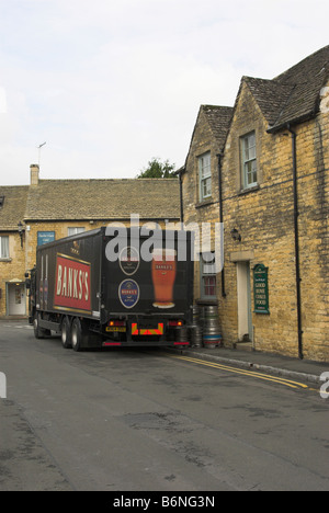 Un dray brasseurs déchargement barils de bière dans un pub de Cotswold. Banque D'Images