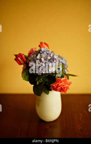 Bol de pommes sur table avec vase de fleurs roses et de l'hortensia Banque D'Images