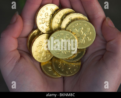 Pièces d'or chocolat en cuppied les paumes des deux mains Banque D'Images