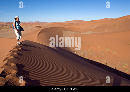 Marcher sur des dunes de Sossusvlei dans le désert de Namib, Namibie Namib Naukluft National Park Banque D'Images