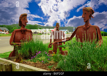 Image d'une découpe de métal sculpture montrant deux pionnières cueillette des fleurs autour d'un vieux Buckboard Wagon Banque D'Images