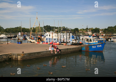 Une femme et deux enfants, étudiez le contenu de filet de pêche sur Lymington Pier Hampshire England UK Banque D'Images