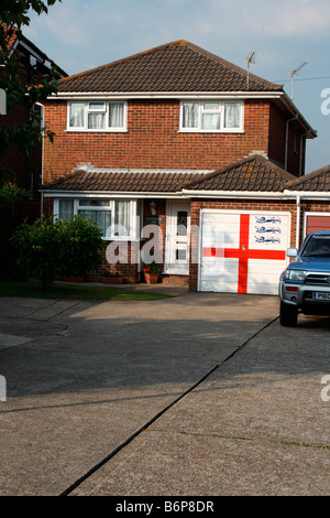 Petite maison individuelle Waterlooville, Portsmouth UK. Porte de garage peinte avec pavillon de St George et trois lions football anglais Banque D'Images