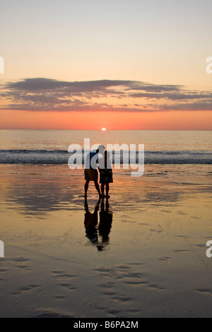 Couple aimant l'embrasse tout en profitant de la plage au coucher du soleil sur la plage Flamingo au Costa Rica Banque D'Images