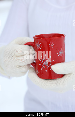 Les mains avec des gants hiver noël holding Coffee Mug Banque D'Images