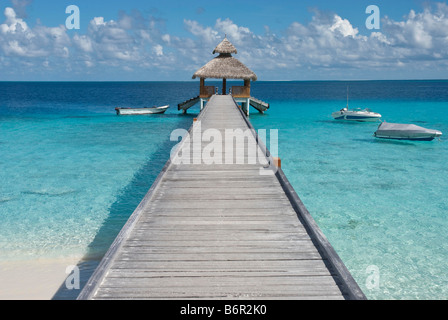 Jetée en bois clair et de bateaux dans la mer tropicale dans les Maldives. Banque D'Images