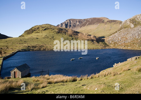 Rhyd Ddu Gwynedd North Wales décembre regardant à travers Llyn y dywarchen avec un hangar à bateaux et trois bateaux de pêche amarrés dans le parc national Eryri Snowdonia Banque D'Images