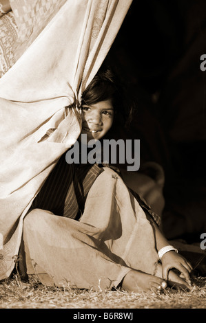 Nomades pauvres jeune indienne assis à l'intérieur de la tente à la maison. L'Andhra Pradesh, Inde sépia Banque D'Images