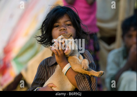 Les indiens pauvres fille jouant avec son petit chien dans la lumière du matin. Focus sélectif. Banque D'Images