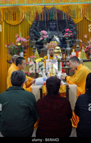 Le peuple chinois pour assister à une cérémonie religieuse avec des moines dans un temple à Guangzhou Chine Guandong Banque D'Images