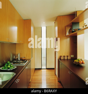 Placards en bois clair au-dessus des unités en cuisine cuisine moderne avec parquet Banque D'Images