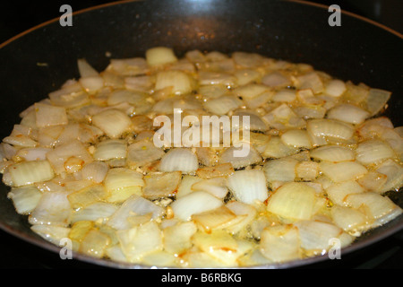 Les oignons en dés dans la poêle. Banque D'Images