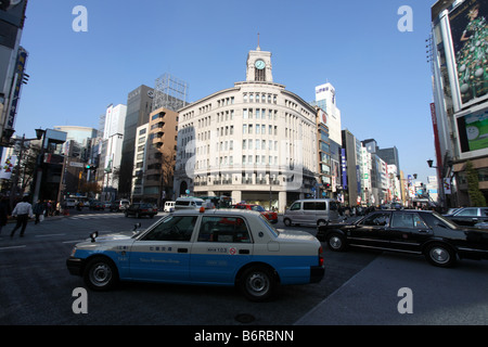 Un taxi bleu passe le Tour de l'horloge sur l'Hattori Wako Department Store à Ginza, Tokyo, Japon Banque D'Images