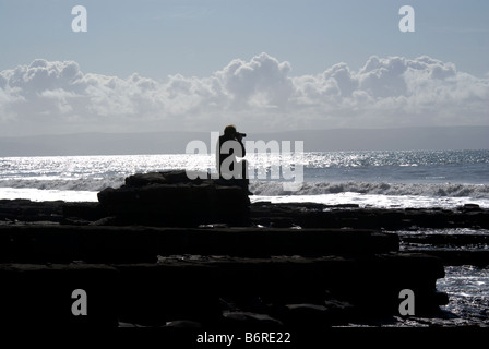 Assis sur des rochers, photographe du glamorgan nash cwm vallée de Glamorgan au Pays de Galles du sud Banque D'Images