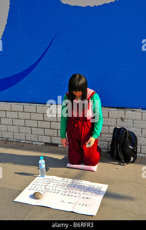 Femme mendiant sur une rue à Beijing Banque D'Images