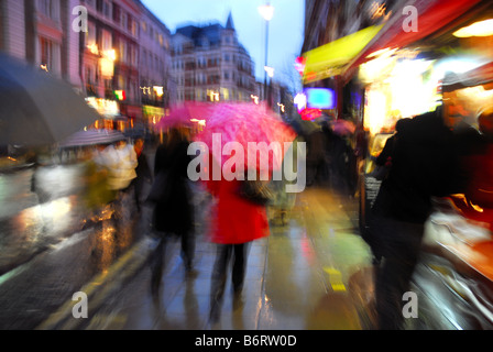 Rainy London street avec les consommateurs et de parasols Banque D'Images