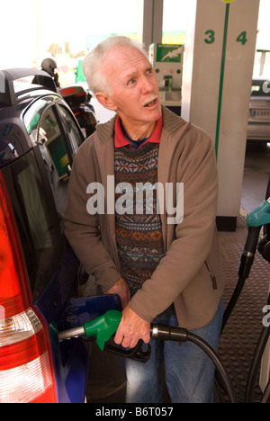 73 ans ex pat anglais de la mise à niveau de voiture avec l'essence à une station dans le Castell de Ferro, Granada, Andalousie, Espagne du sud. Banque D'Images