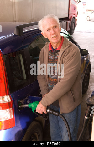 73 ans ex pat anglais de la mise à niveau de voiture avec l'essence à une station dans le Castell de Ferro, Granada, Andalousie, Espagne du sud Banque D'Images