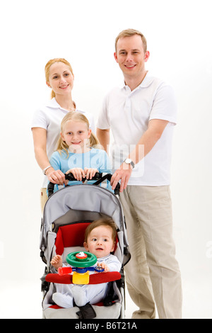 Les parents et la fille holding baby carriage smiling portrait Banque D'Images