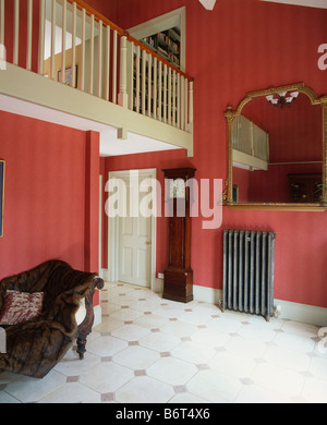 Grand miroir au-dessus du radiateur récupéré à hauteur double hall avec papier peint à rayures rouge et blanc en carrelage de marbre Banque D'Images