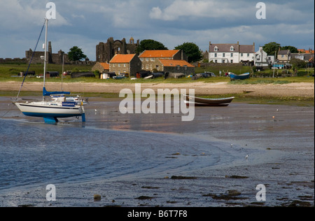 Vue de la plage à l'île sacrée de Lindisfarne, à travers la baie, vers le village et Prieuré de Lindisfarne. Banque D'Images