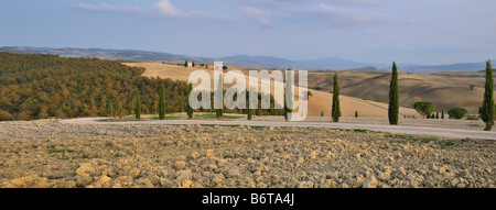 Paysage panoramique de l'Italien blanc route bordée de cyprès avec petite chapelle sur la colline au loin Banque D'Images