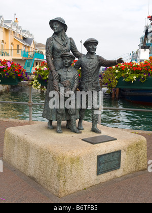 Statue d'Annie Moore et ses 2 frères sur l'eau à port de Cobh, dans le comté de Cork, en République d'Irlande. Banque D'Images