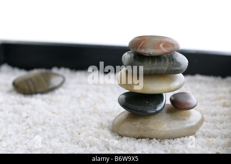 Rochers lisses empilés dans un jardin Zen miniature à sable Banque D'Images