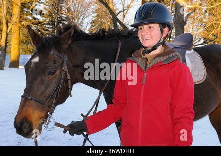 Ambiance teenage rider marcher son cheval retour à l'étable après un hiver hack Banque D'Images