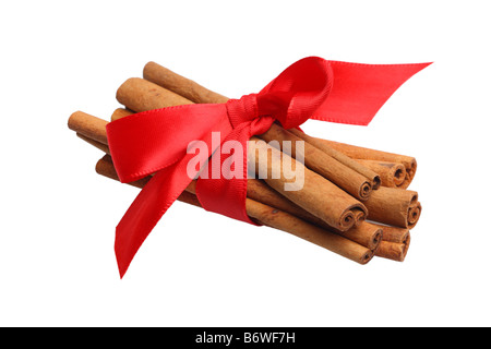 Les bâtons de cannelle attaché avec du ruban rouge coupé isolé sur fond blanc Banque D'Images
