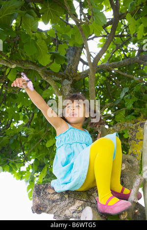 Une fille grimper un arbre Banque D'Images