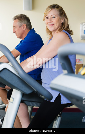 Un homme et une femme à l'aide de vélos d'exercice Banque D'Images