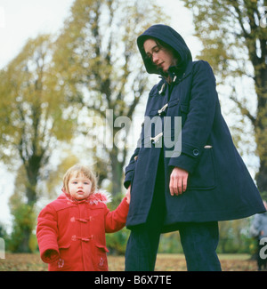 Une mère et sa fille tout-petit en duffle coats sur un jour d'automne dans le parc, Walthamstow, London England UK KATHY DEWITT Banque D'Images