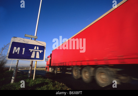 Camion passant panneau routier indiquant début de l'autoroute M1 près de Leeds Yorkshire UK Banque D'Images