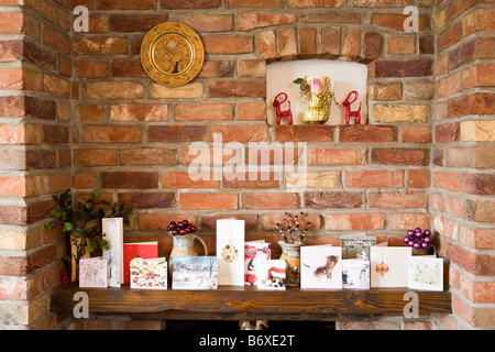 Cartes de Noël organisé sur une cheminée en pays home UK Banque D'Images