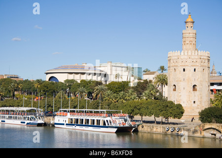 Séville Espagne La Torre del Oro, avec des bateaux d'excursion en face sur le fleuve Guadalquivir Banque D'Images