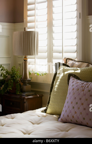 Violette et verte oreillers décoratifs sur la fenêtre près de lit Banque D'Images