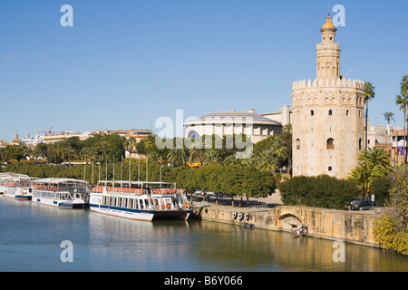 Séville Espagne La Torre del Oro, avec des bateaux d'excursion en face sur le fleuve Guadalquivir Banque D'Images